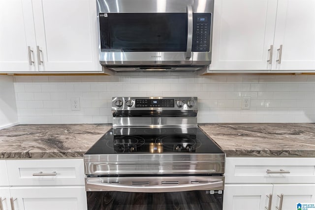 kitchen featuring light stone countertops, white cabinets, and stainless steel appliances