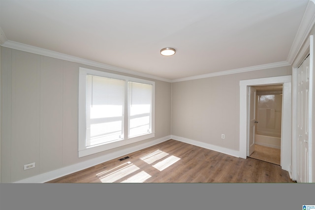 empty room featuring hardwood / wood-style flooring and ornamental molding