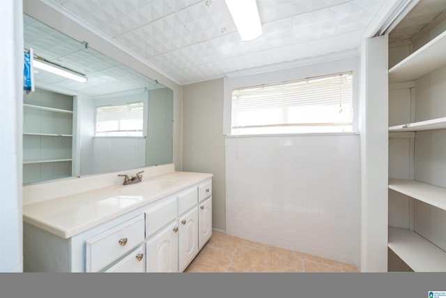 bathroom with a wealth of natural light, tile patterned flooring, and vanity