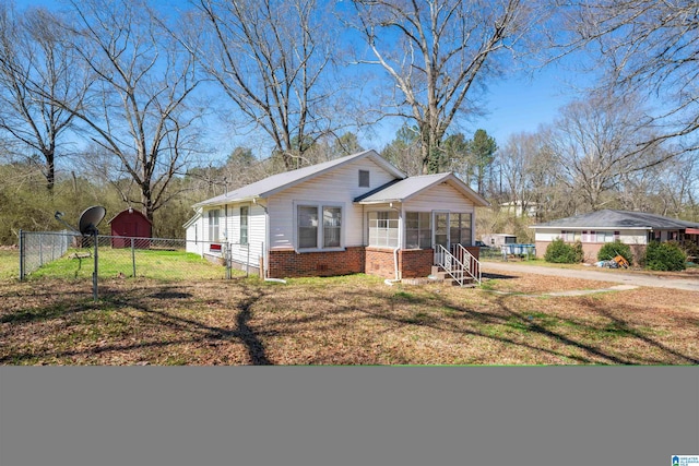 view of front facade with a front yard and a sunroom