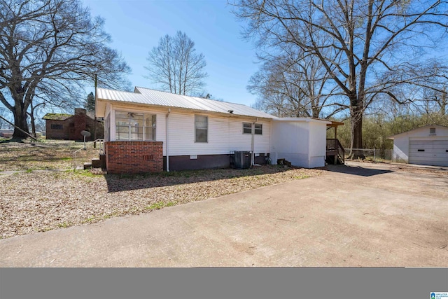 view of front of house featuring a garage, an outbuilding, and central air condition unit