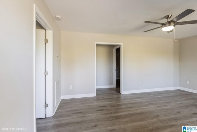 spare room with ceiling fan and dark wood-type flooring