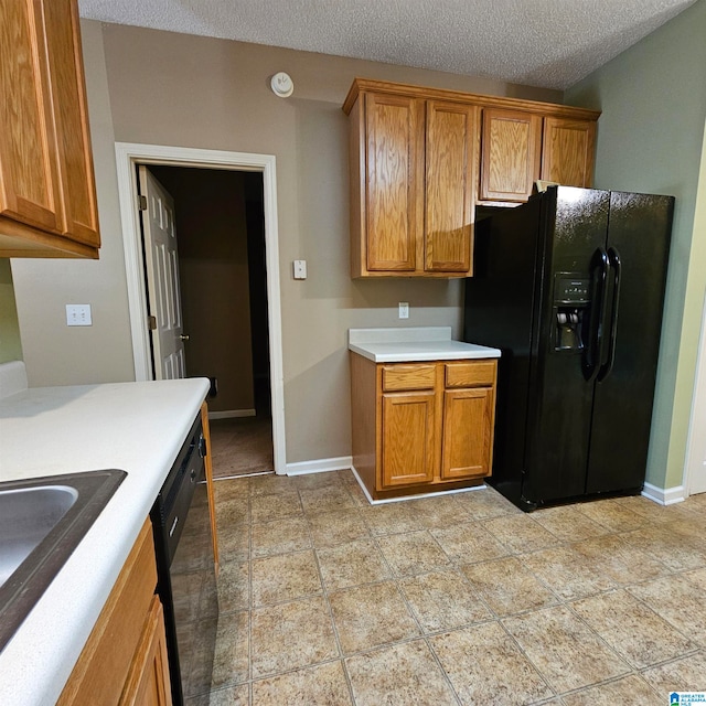 kitchen featuring sink, black appliances, and a textured ceiling