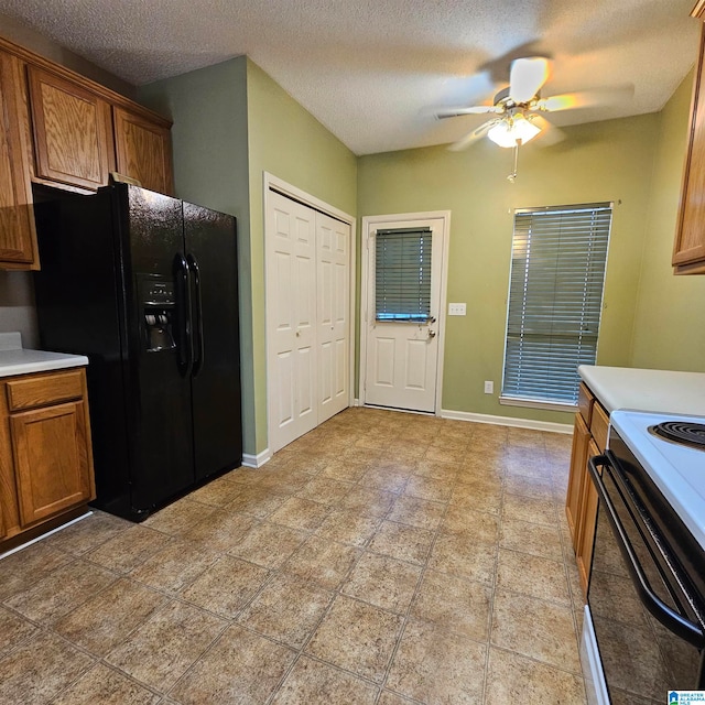 kitchen with a textured ceiling, white electric stove, black fridge, and ceiling fan