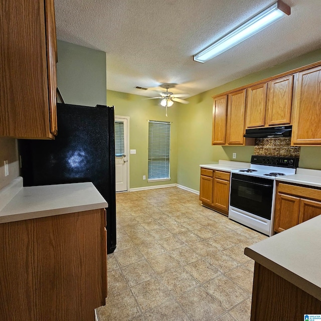 kitchen featuring backsplash, white range with electric cooktop, black refrigerator, ceiling fan, and a textured ceiling