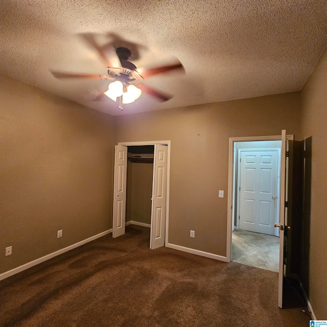 unfurnished bedroom featuring ceiling fan, dark carpet, a textured ceiling, and a closet