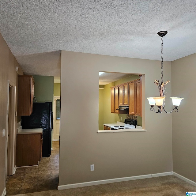 kitchen with an inviting chandelier, white range oven, pendant lighting, a textured ceiling, and black refrigerator