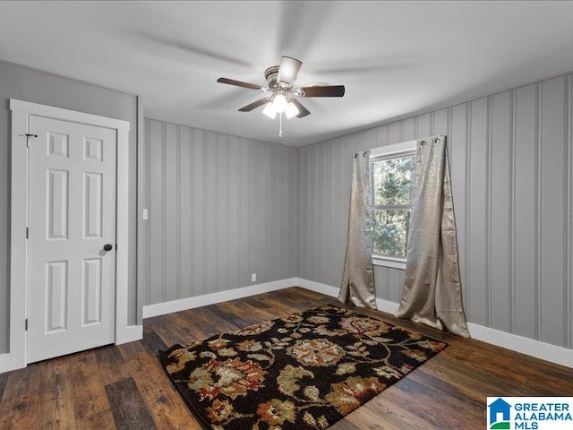 empty room with dark hardwood / wood-style floors and ceiling fan