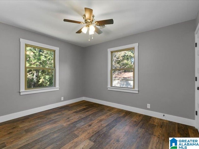 spare room featuring dark hardwood / wood-style floors, ceiling fan, and a healthy amount of sunlight