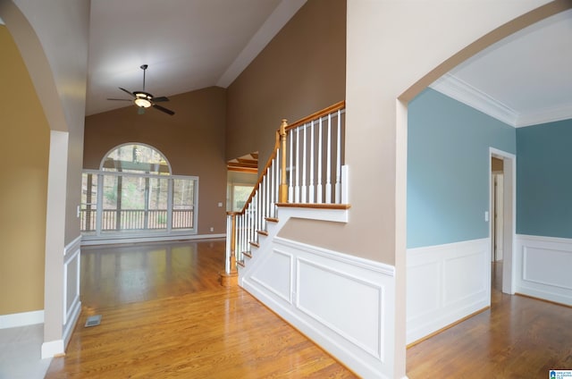 stairway with lofted ceiling, hardwood / wood-style flooring, ceiling fan, and ornamental molding