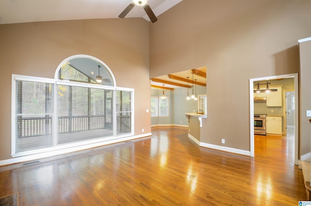 unfurnished living room featuring plenty of natural light, high vaulted ceiling, and light hardwood / wood-style flooring