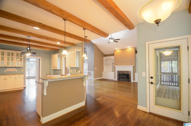 kitchen featuring a high end fireplace, a kitchen breakfast bar, dark hardwood / wood-style flooring, pendant lighting, and white cabinets