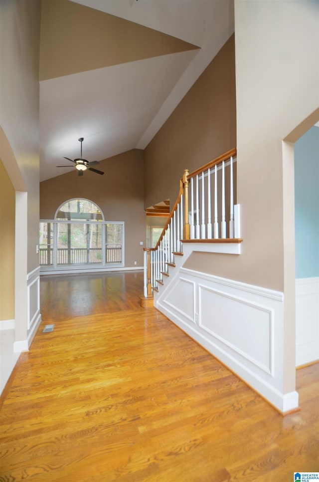 interior space featuring ceiling fan, high vaulted ceiling, and light hardwood / wood-style flooring