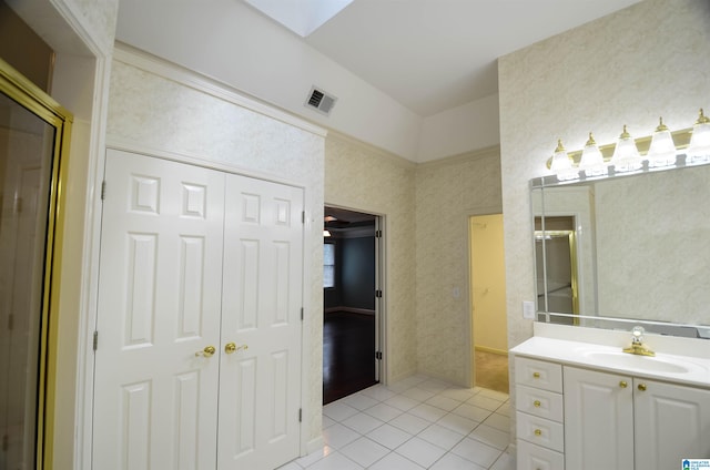 bathroom featuring tile patterned floors, vanity, and a skylight