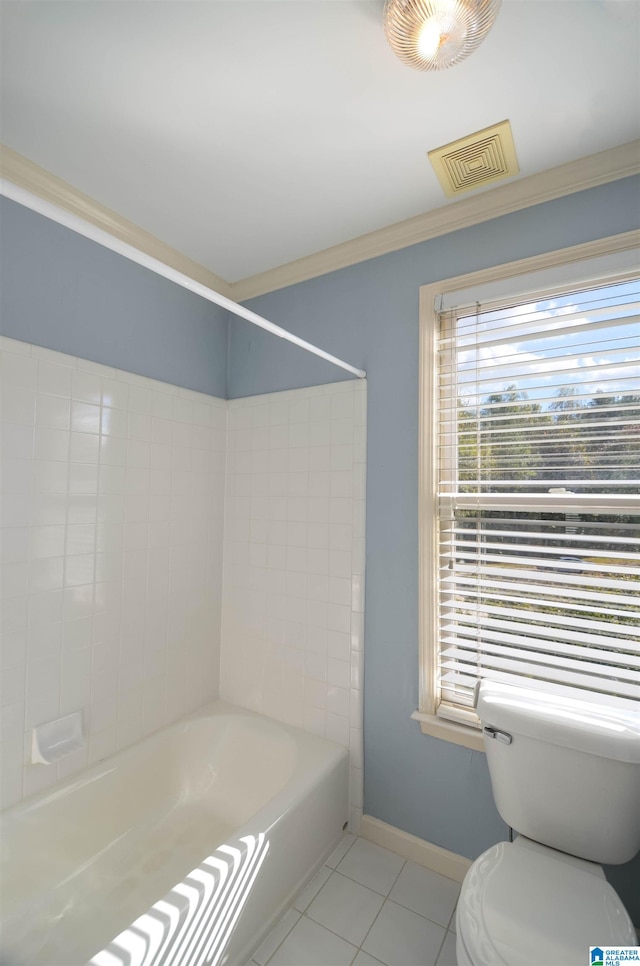 bathroom featuring tile patterned flooring, tiled shower / bath combo, toilet, and crown molding