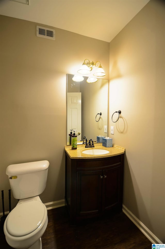 bathroom with vanity, toilet, and wood-type flooring