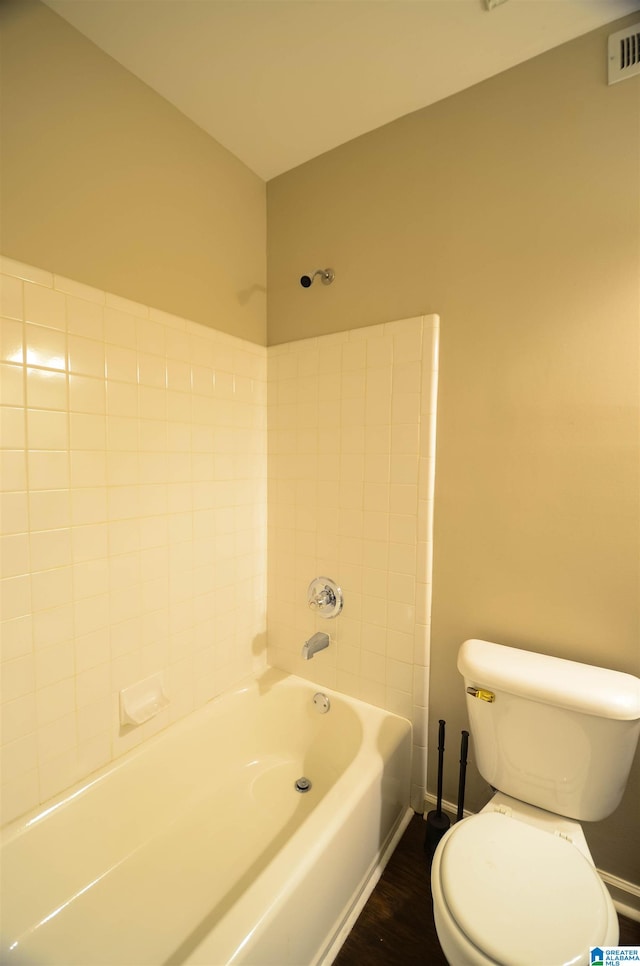 bathroom featuring hardwood / wood-style flooring, bathtub / shower combination, and toilet