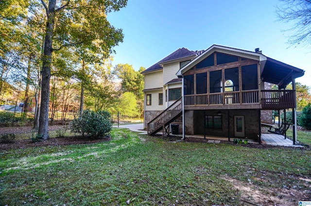 rear view of property with a patio area, a sunroom, a yard, and a deck