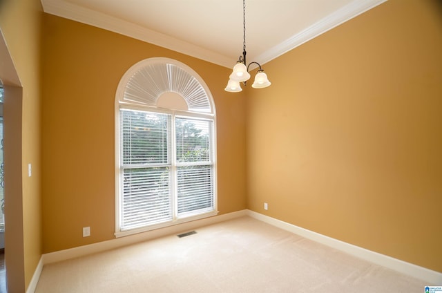 carpeted empty room featuring ornamental molding and a chandelier