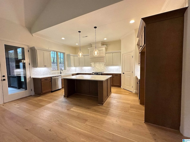 kitchen featuring decorative backsplash, a center island, appliances with stainless steel finishes, and light hardwood / wood-style flooring