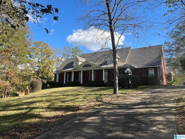 cape cod-style house with a front yard