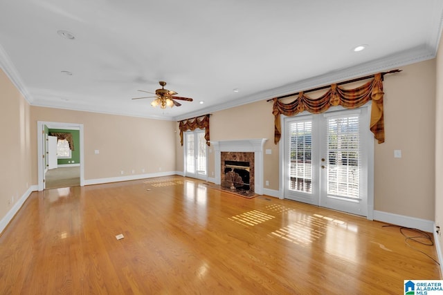 unfurnished living room with ceiling fan, crown molding, and light hardwood / wood-style floors