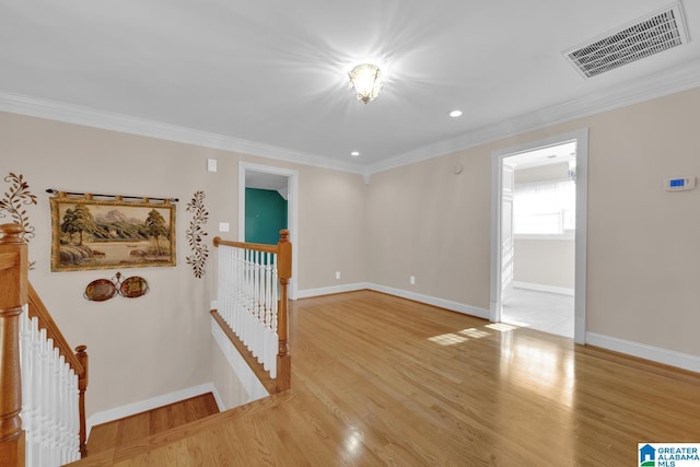 spare room with light hardwood / wood-style floors and crown molding