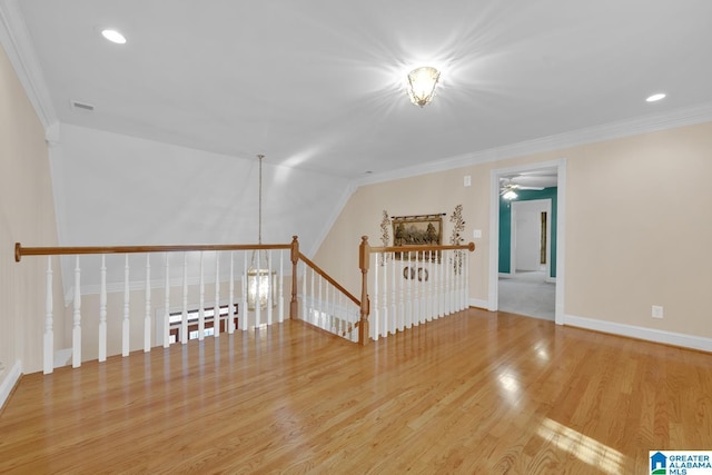 spare room featuring ceiling fan, light wood-type flooring, and ornamental molding