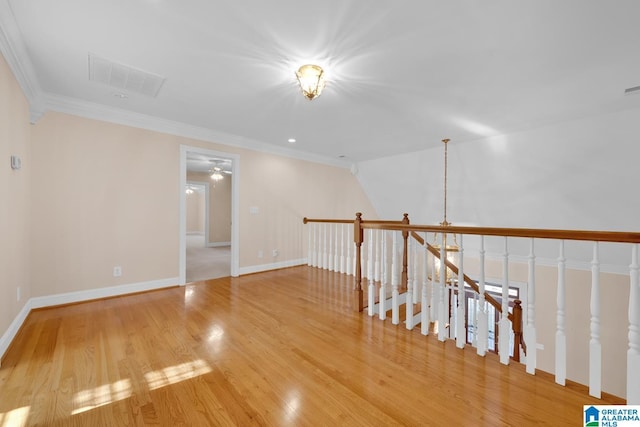 spare room featuring hardwood / wood-style flooring, ceiling fan, and ornamental molding