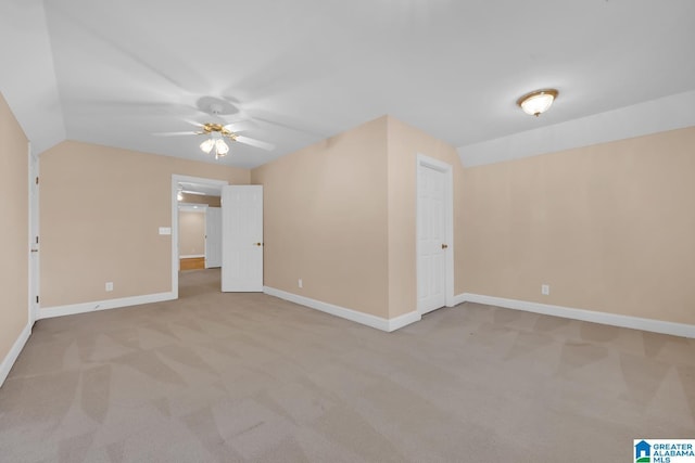 carpeted spare room with ceiling fan and lofted ceiling