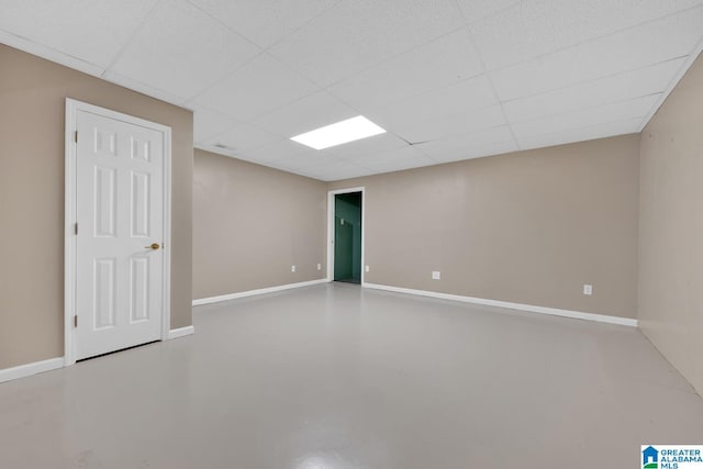 spare room with a paneled ceiling and concrete flooring