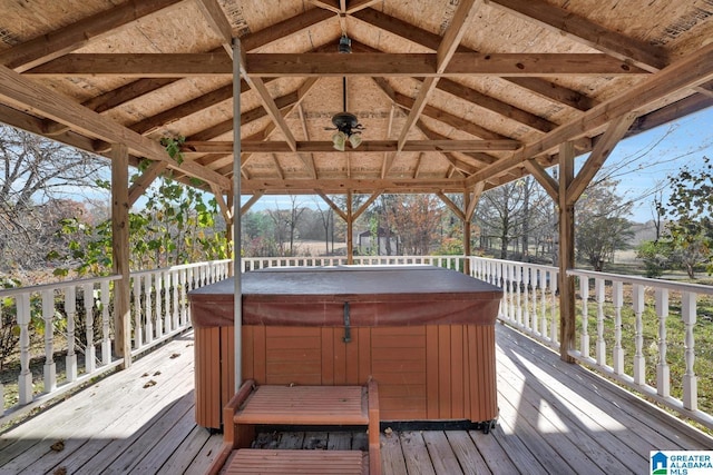 wooden terrace with a gazebo, a hot tub, and ceiling fan