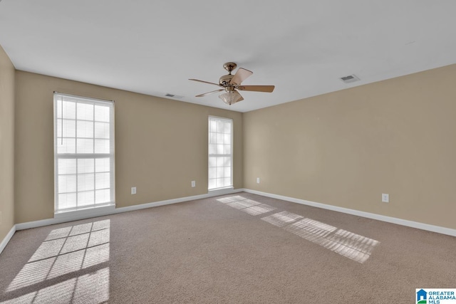 carpeted spare room featuring ceiling fan