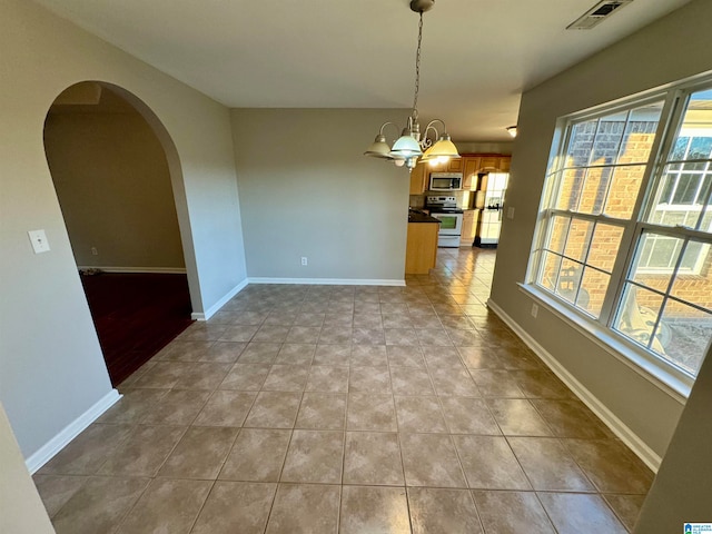 unfurnished dining area with a chandelier