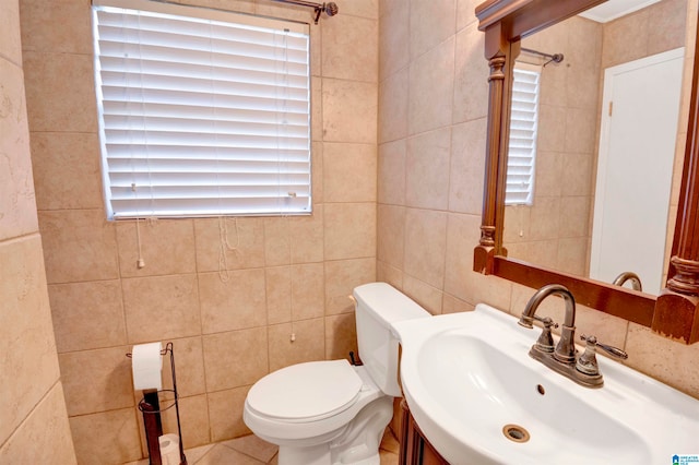 bathroom with vanity, toilet, and tile walls