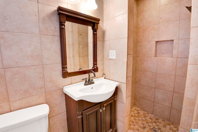 bathroom featuring vanity, toilet, and tile walls