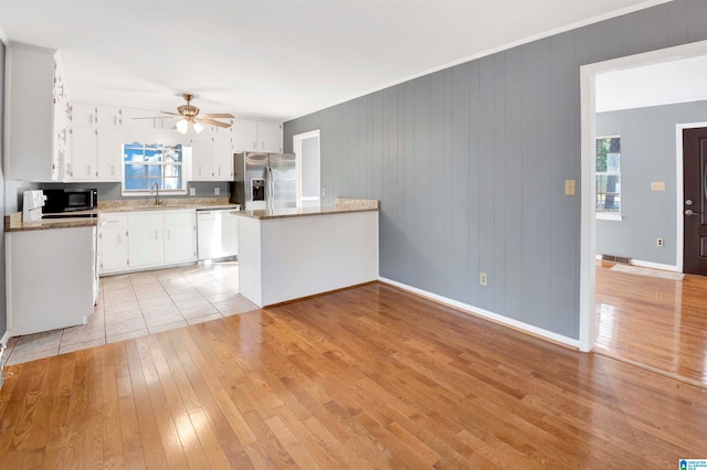 kitchen featuring white cabinets, sink, light hardwood / wood-style flooring, light stone countertops, and appliances with stainless steel finishes