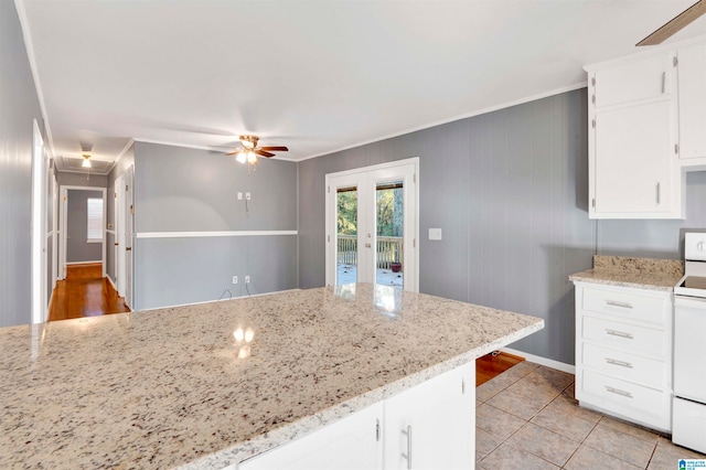 kitchen with light stone countertops, white cabinetry, and light tile patterned flooring