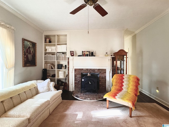 living room with wood-type flooring, a wood stove, ceiling fan, and crown molding