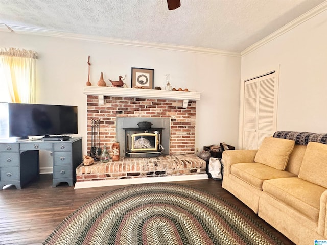 living room featuring ornamental molding, a textured ceiling, a wood stove, and dark wood-type flooring