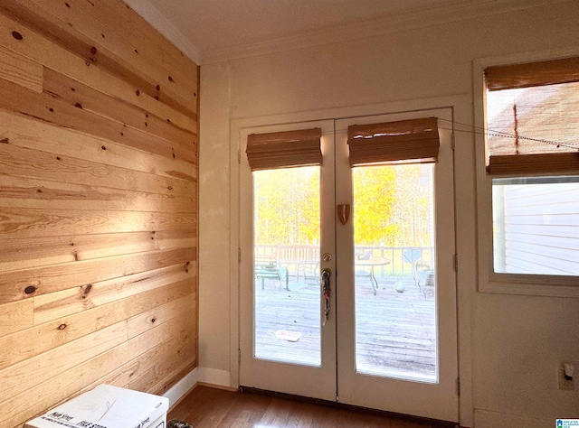 doorway featuring wooden walls, french doors, ornamental molding, and hardwood / wood-style flooring