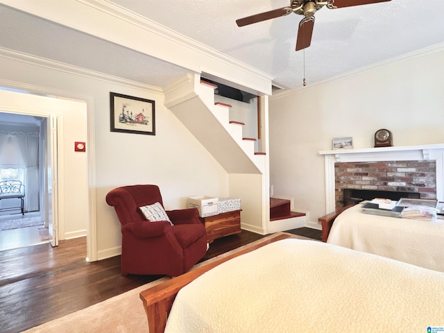 bedroom with a textured ceiling, crown molding, ceiling fan, and dark wood-type flooring