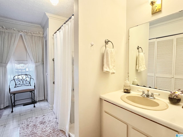 bathroom with a shower with shower curtain, vanity, crown molding, and a textured ceiling