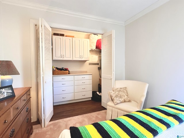 bedroom with hardwood / wood-style floors, a closet, and crown molding