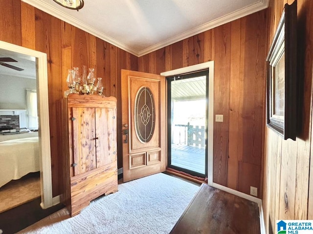 entryway with wood walls, ceiling fan with notable chandelier, and ornamental molding