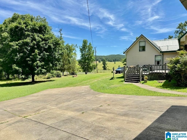 exterior space with a deck and a lawn