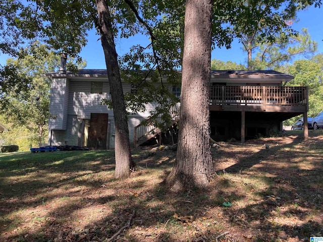 back of house with a lawn and a wooden deck