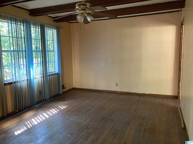 spare room with ceiling fan, beamed ceiling, and dark wood-type flooring