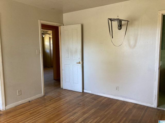 unfurnished room featuring ceiling fan and dark wood-type flooring