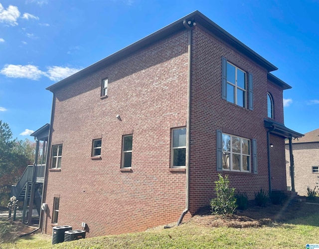 view of home's exterior with central air condition unit and a yard